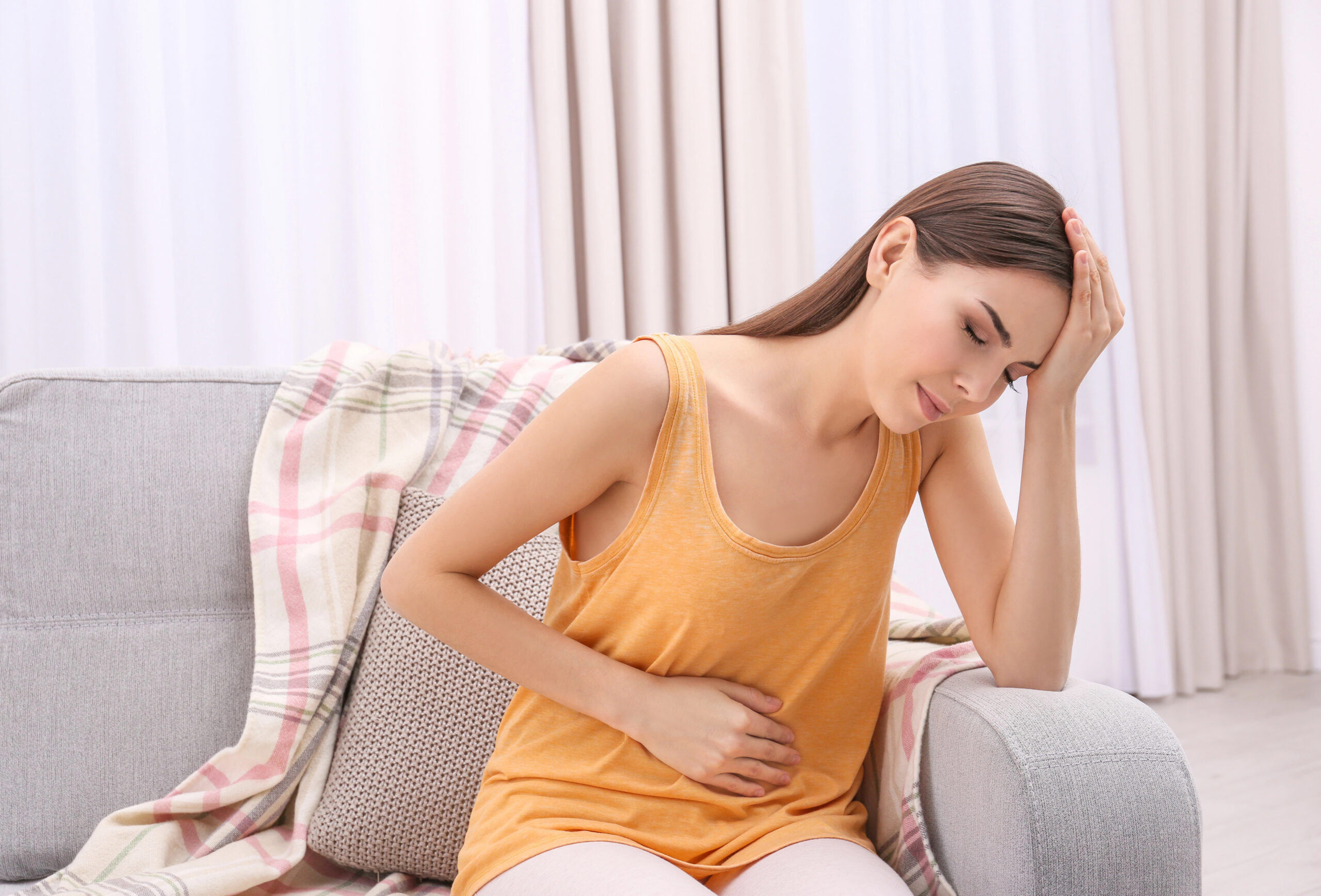 Donna con dolore di stomaco e addominale
